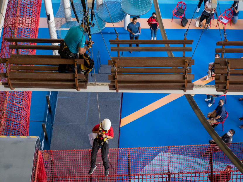 An instructor securing the participant's weight before lowering her down. 
