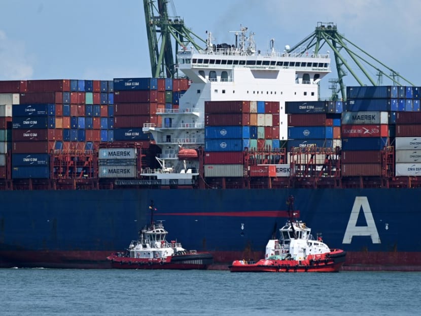 Pilot boats guide a container ship to dock at the port of Singapore on June 14, 2021.