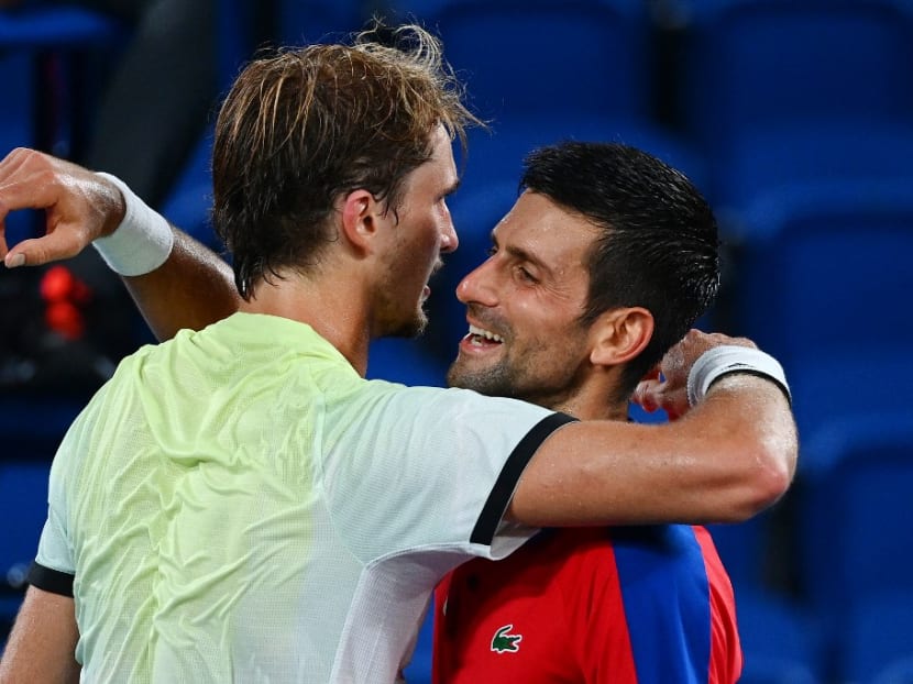 Serbia's Novak Djokovic congratulates Germany's Alexander Zverev for winning their Tokyo 2020 Olympic Games men's singles semifinal tennis match at the Ariake Tennis Park in Tokyo on July 30, 2021.