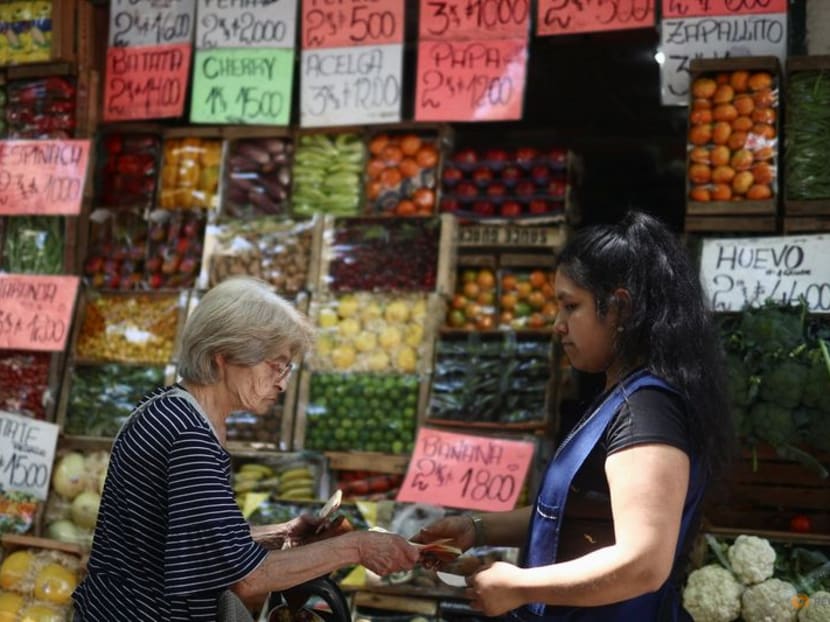 FILE PHOTO: A woman buys fruits and vegetables at a greengrocery store in Buenos Aires, Argentina, December 12, 2023. REUTERS/Tomas Cuesta/File Photo