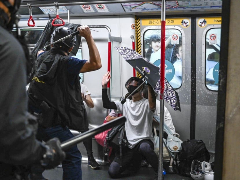 Members of the Special Tactical Squad enter a stationary train at Prince Edward station.