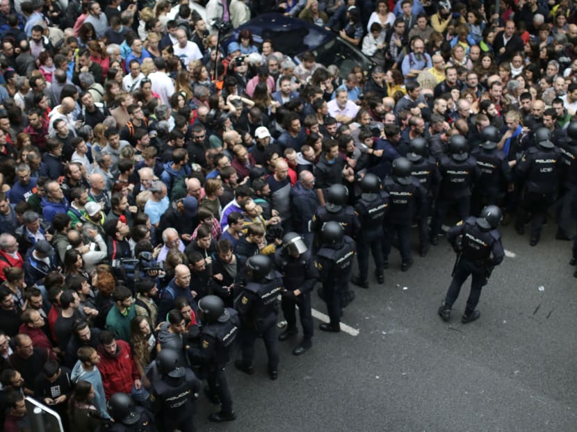 Spanish National Police prevents people from entering a voting site at a school assigned to be a polling station by the Catalan government in Barcelona, Spain, Sunday, 1 Oct. 2017. PHOTO: AP