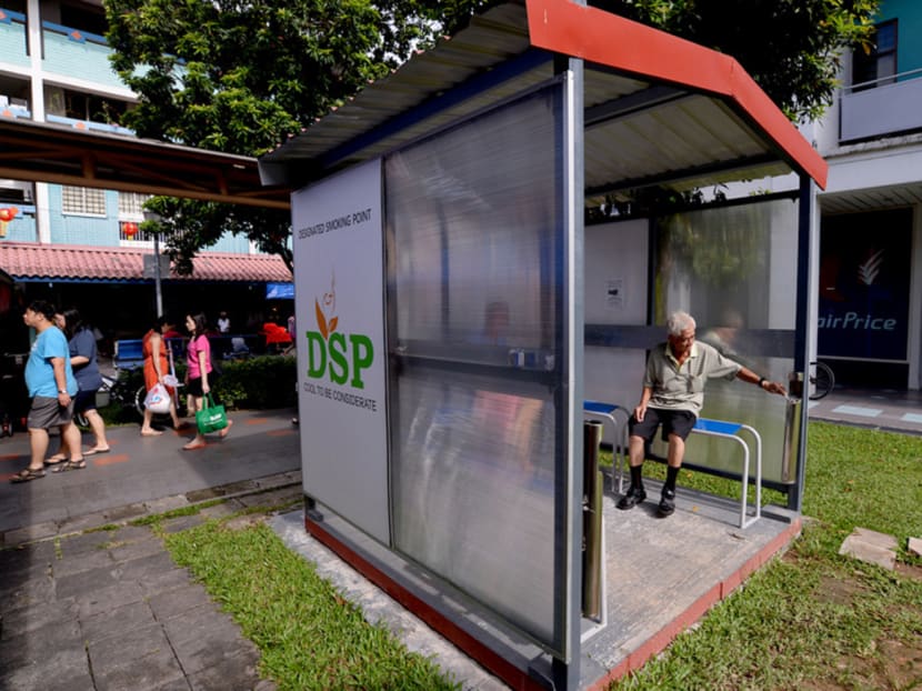 A smoker using one of the 50 Designated Smoking Points located around Nee Soon South. Non-smokers said the amount of secondary smoke and litter had gone down in the area. Photo: Robin Choo