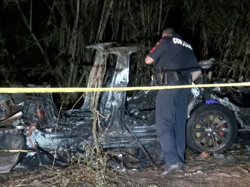The remains of a Tesla vehicle are seen after it crashed in The Woodlands, Texas, April 17, 2021, in this still image from video obtained via social media. The remains of a Tesla vehicle are seen after it crashed in The Woodlands, Texas, April 17, 2021, in this still image from video obtained via social media.