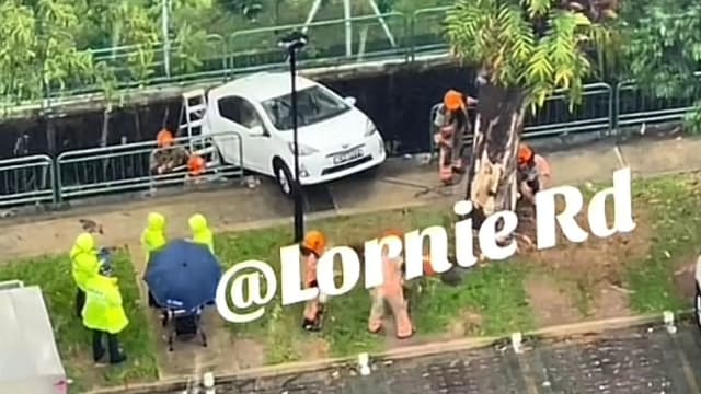 大巴窑汽车倒车半坠沟渠 司机受困驾驶座