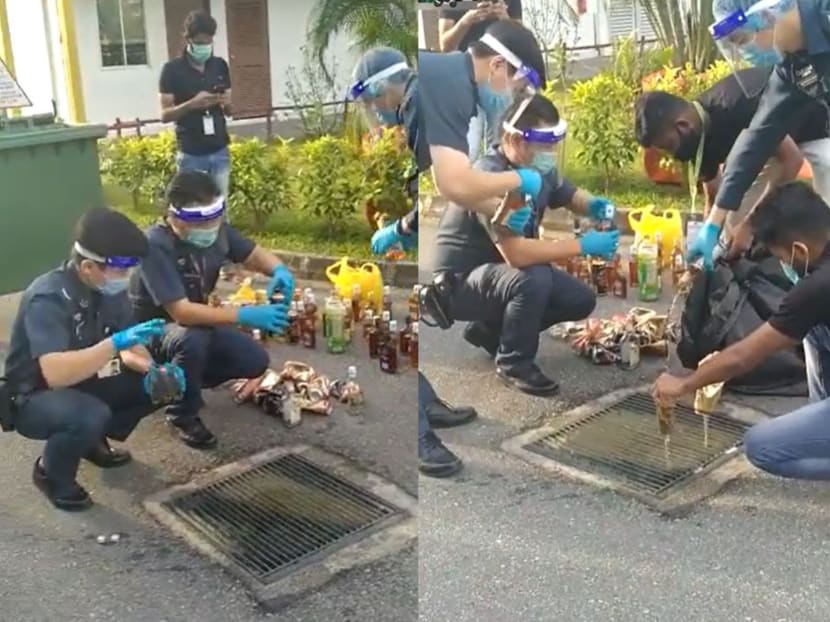 A video posted on the Singapore Road Accident Facebook page on Thursday afternoon showed uniformed officers emptying bottles of what looked like beer and liquor into a drain. A video posted on the Singapore Road Accident Facebook page on Thursday afternoon showed uniformed officers emptying bottles of what looked like beer and liquor into a drain.