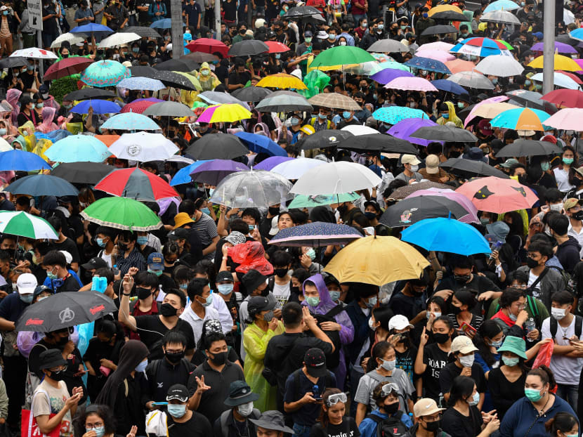 Pro-democracy protesters use umbrellas to shelter from the rain at Wongwian Yai in Bangkok on Oct 17, 2020, as they continue to defy an emergency decree banning gatherings.