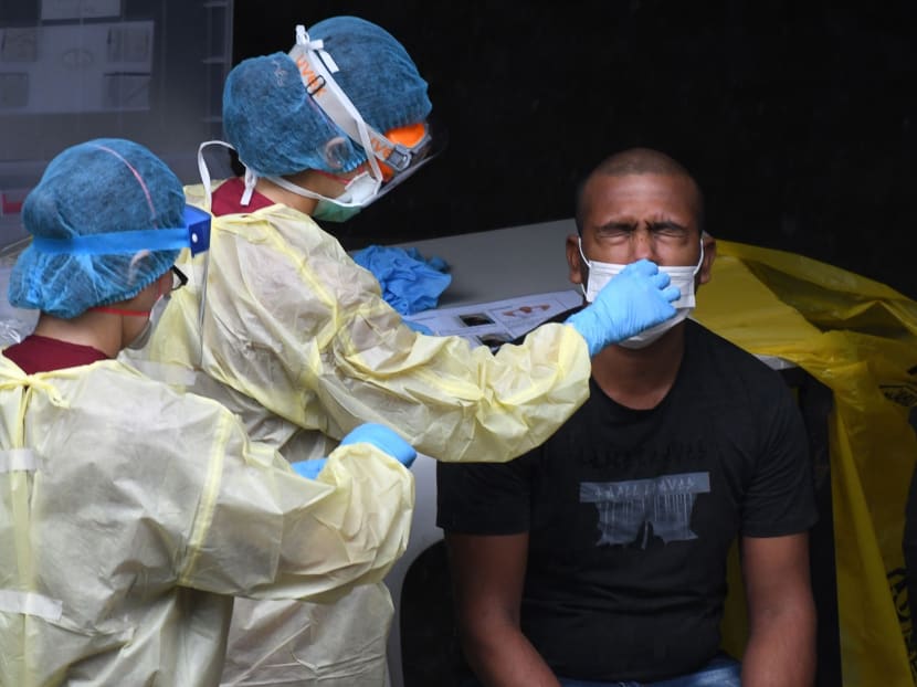 Singapore healthcare workers collecting a nasal swab sample from a migrant worker for Covid-19 testing. Singapore healthcare workers collecting a nasal swab sample from a migrant worker for Covid-19 testing.