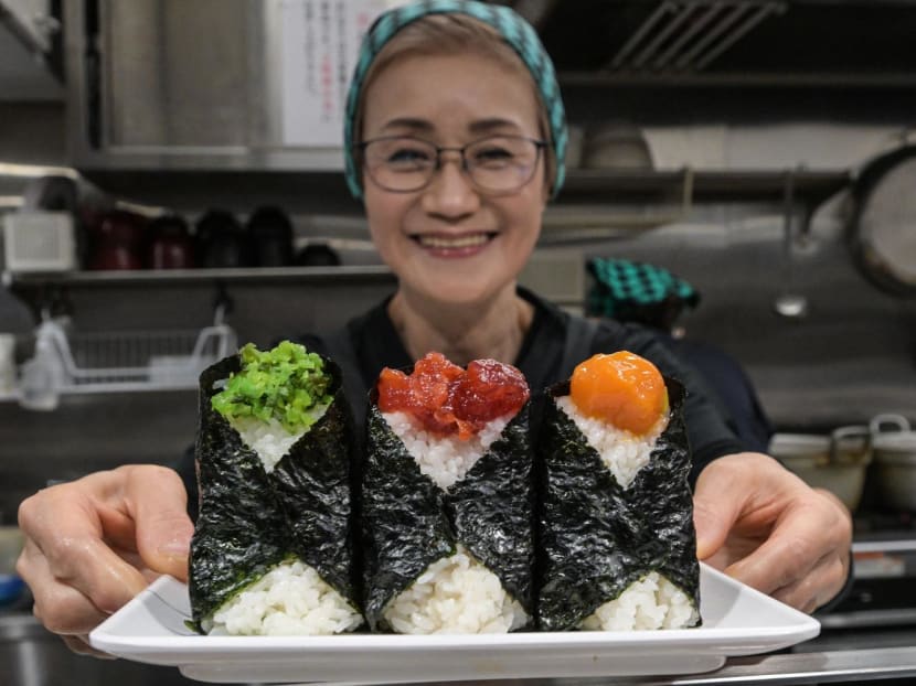 This photo taken on Dec 7, 2023 shows Yumiko Ukon, who runs the restaurant Onigiri Bongo, a shop specialising in rice balls known as "onigiri", posing with rice balls she made in the Otsuka area of Tokyo.