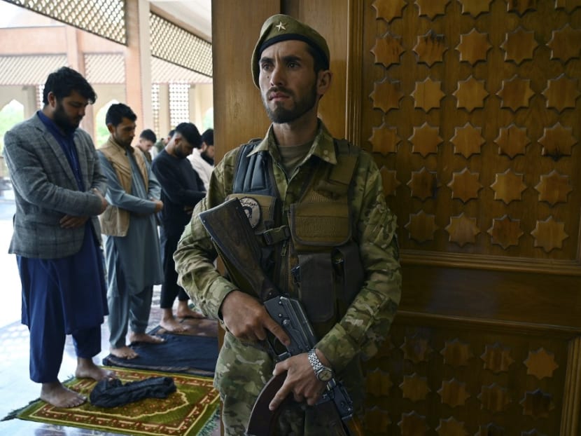 An Afghan security personnel stands guard as Muslim devotees offer prayers to start the Eid-al-Fitr festival marking the end of the Islamic holy fasting month of Ramadan during a three-day ceasefire agreed by the warring Taliban and Afghan forces, at the Abdul Rahman Mosque in Kabul on May 13, 2021. An Afghan security personnel stands guard as Muslim devotees offer prayers to start the Eid-al-Fitr festival marking the end of the Islamic holy fasting month of Ramadan during a three-day ceasefire agreed by the warring Taliban and Afghan forces, at the Abdul Rahman Mosque in Kabul on May 13, 2021.