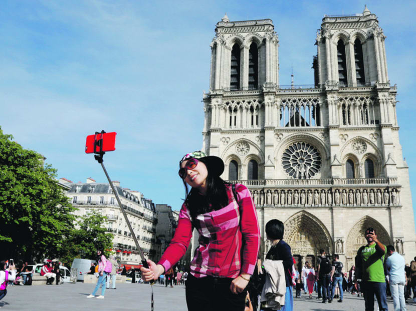 A Chinese tourist taking a selfie in front of the Notre Dame Cathedral in Paris, France. A survey reveals that more travellers are seeking individualised itineraries. Photo: REUTERS