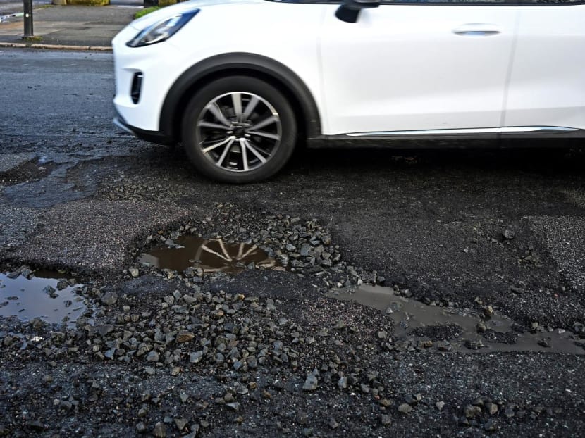 A car is driven past a pothole in a damaged road in Liverpool, north west England on Jan 30, 2024. A car is driven past a pothole in a damaged road in Liverpool, north west England on Jan 30, 2024.