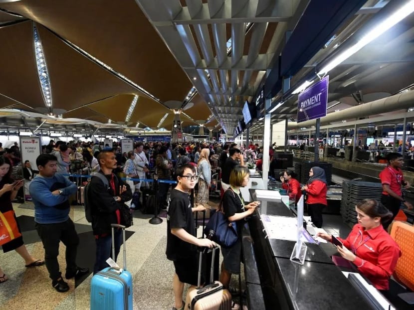 The departure hall of the airport was jam-packed with travellers waiting in line at almost every counter.