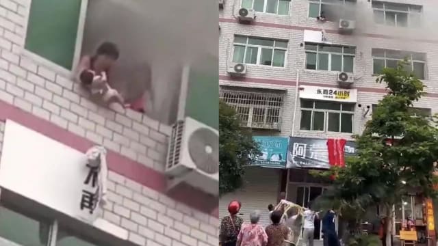 大楼起火母亲将宝宝抛下楼求生 街坊齐心协力救下他